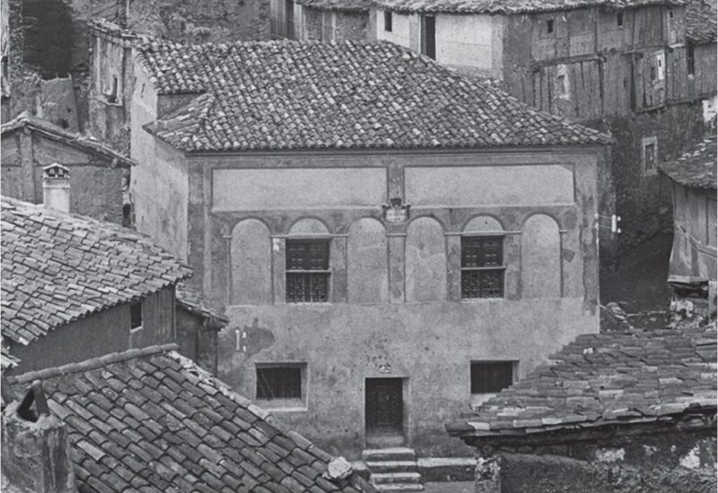 En esta imagen de inicios del siglo XX, se puede ver el aspecto que presententaba este edificio, con una reforma clasicista que habia cambiado la configuración de la fachada cegando los arcos de medio punto en planta baja y añadiendo unas arquerias de yeso en fachadada. Cabe destacar el acceso independiente a las dos alturas del edificio, así como la ubicación del calabozo en la parte trasera del inmueble.